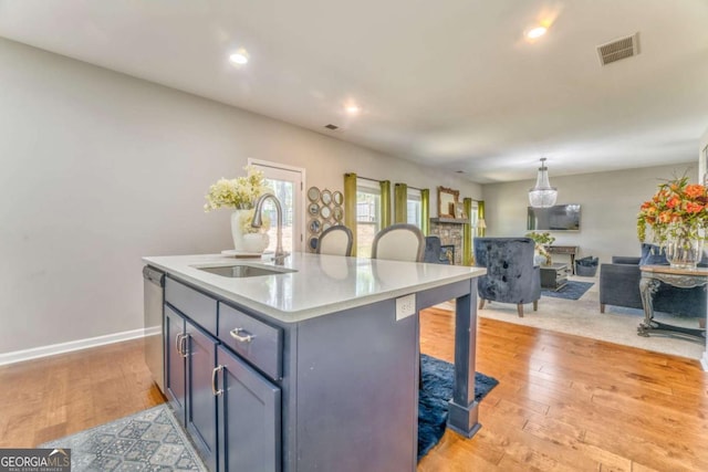 1302 Gardenia Ct, Villa Rica, GA 30180 - kitchen featuring stainless steel dishwasher, light wood-style flooring, visible vents, light countertops, and a sink