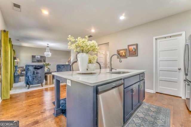 1302 Gardenia Ct, Villa Rica, GA 30180 - kitchen featuring light wood-style flooring, light countertops, visible vents, appliances with stainless steel finishes, and a sink