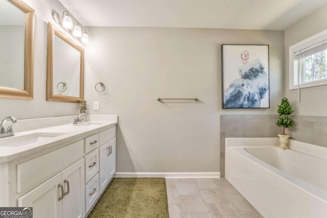 1302 Gardenia Ct, Villa Rica, GA 30180 - bathroom featuring a bath, double vanity, a sink, and baseboards