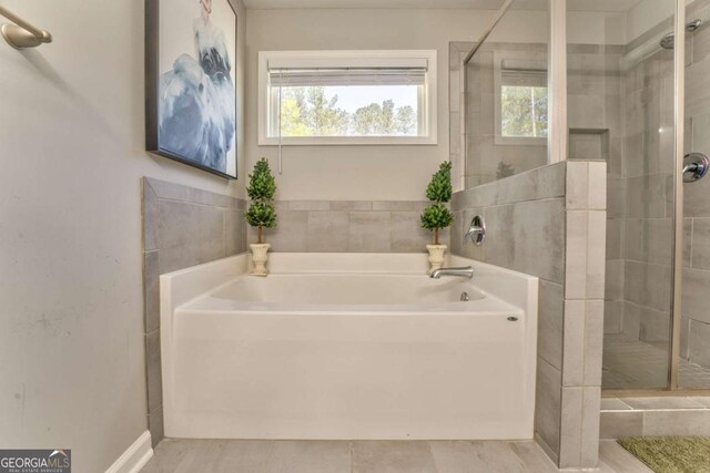 1302 Gardenia Ct, Villa Rica, GA 30180 - full bath featuring a bath, baseboards, and a stall shower