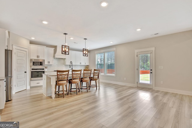 196 Saddleridge Trl, Senoia, GA 30276 - kitchen with visible vents, recessed lighting, appliances with stainless steel finishes, premium range hood, and a breakfast bar area