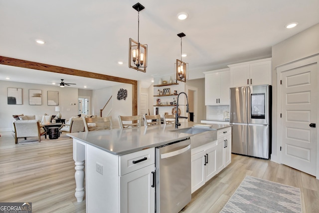 196 Saddleridge Trl, Senoia, GA 30276 - kitchen with ceiling fan with notable chandelier, white cabinets, a sink, stainless steel appliances, and a center island with sink