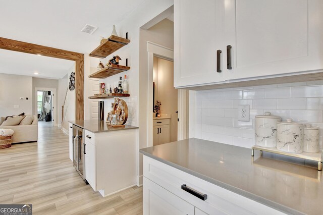 196 Saddleridge Trl, Senoia, GA 30276 - kitchen featuring open floor plan, white cabinetry, backsplash, visible vents, and light wood finished floors