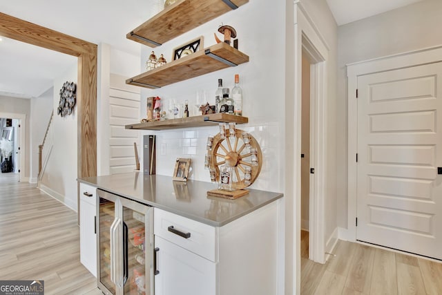 196 Saddleridge Trl, Senoia, GA 30276 - bar featuring a bar, light wood-type flooring, decorative backsplash, and wine cooler