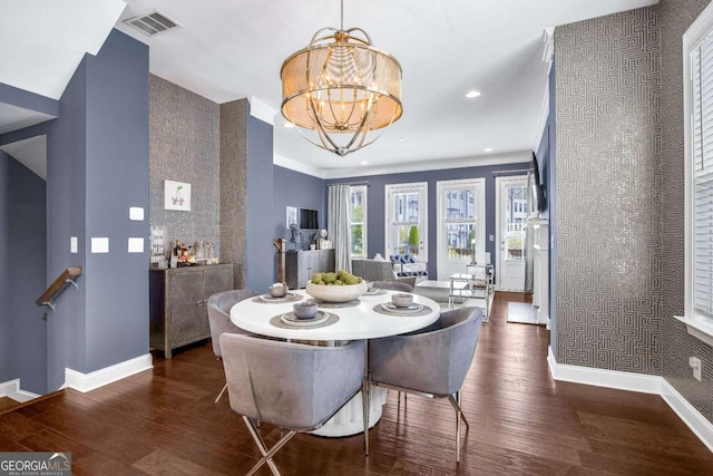 dining space featuring wood finished floors, baseboards, visible vents, and a notable chandelier