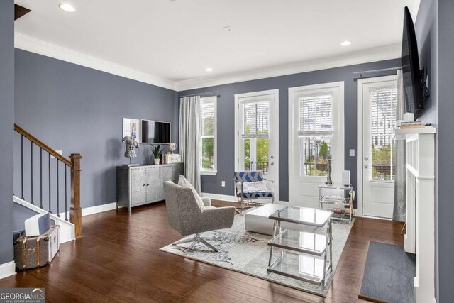 living room with ornamental molding, baseboards, stairway, and wood finished floors