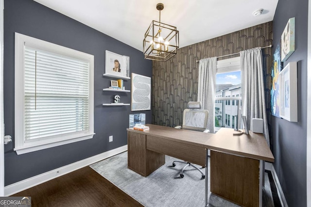 office area with baseboards, an inviting chandelier, and wood finished floors