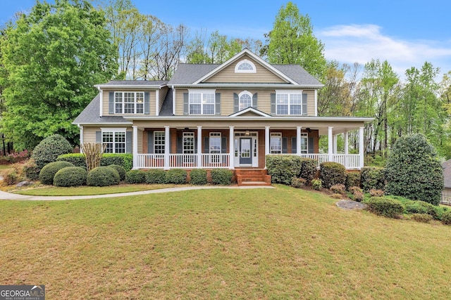 colonial inspired home featuring a porch and a front yard