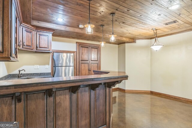 interior space with visible vents, dark countertops, freestanding refrigerator, baseboards, and concrete flooring