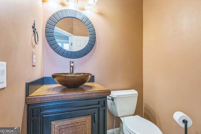 half bath featuring vanity and toilet