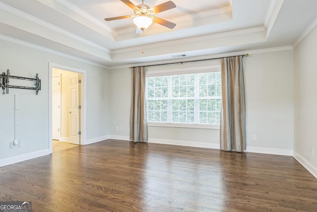 empty room featuring crown molding, ceiling fan, wood finished floors, and a raised ceiling