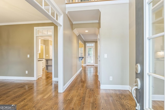 foyer with ornamental molding, wood finished floors, and baseboards