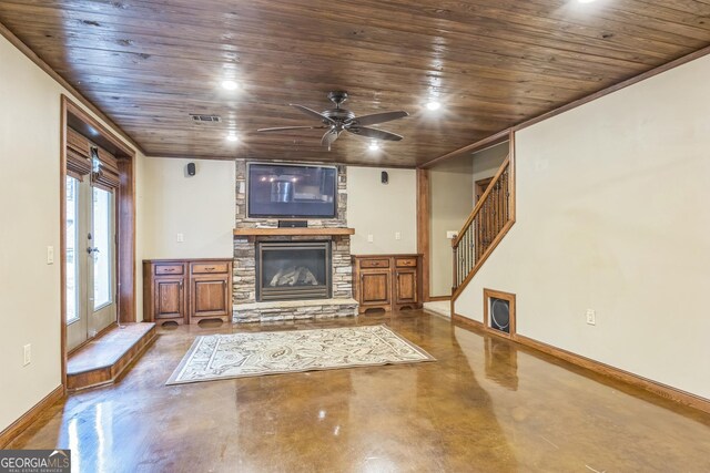 unfurnished living room with stairway, a fireplace, baseboards, wood ceiling, and finished concrete floors