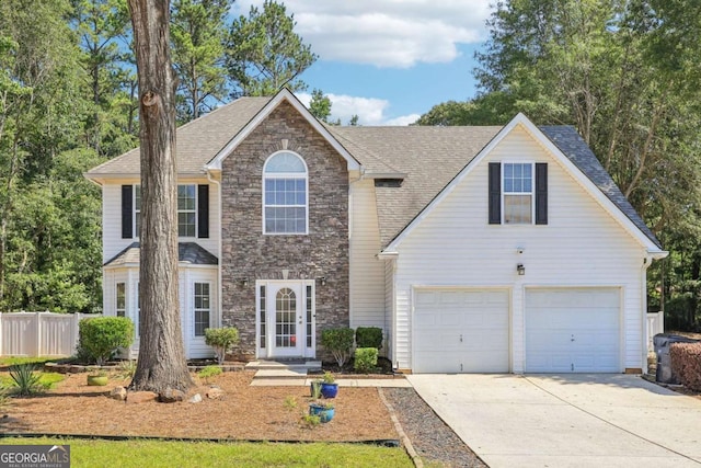 view of front of house with driveway, stone siding, a garage, fence, and a shingled roof