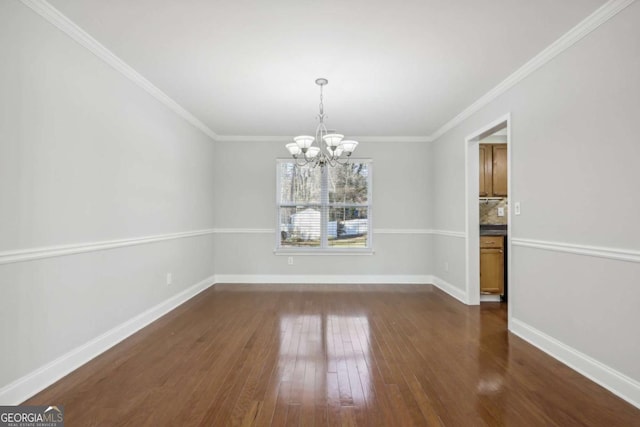 unfurnished dining area featuring a notable chandelier, dark wood-style flooring, baseboards, and crown molding