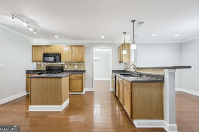 kitchen featuring black microwave, tasteful backsplash, ornamental molding, a sink, and range with gas cooktop