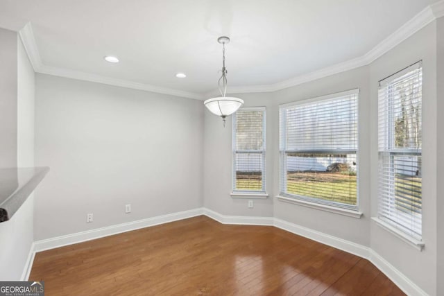 unfurnished dining area featuring crown molding, baseboards, recessed lighting, and hardwood / wood-style flooring