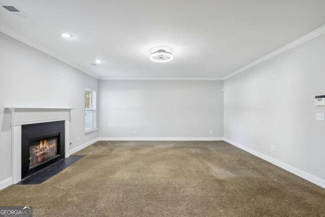 unfurnished living room with ornamental molding, baseboards, carpet, and a fireplace with flush hearth