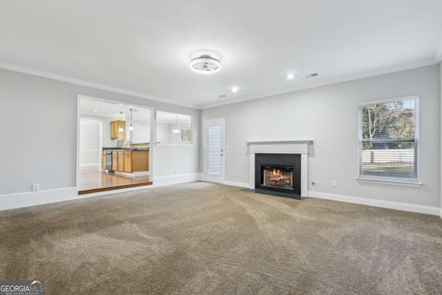 unfurnished living room with crown molding, a fireplace with flush hearth, light colored carpet, visible vents, and baseboards