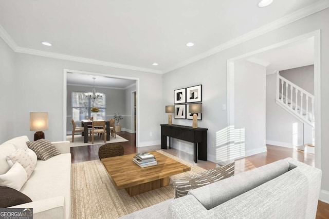 living room with baseboards, an inviting chandelier, wood finished floors, and stairs