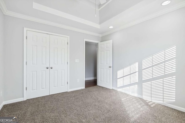 unfurnished bedroom with crown molding, a closet, recessed lighting, carpet floors, and baseboards