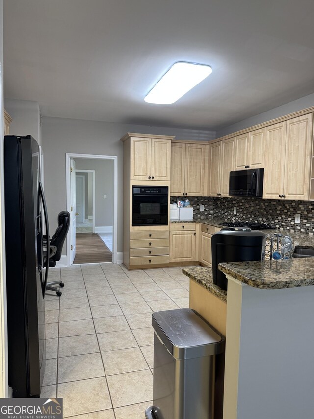 135 Danube Trl, Stockbridge, GA 30281 - kitchen with baseboards, light brown cabinets, light tile patterned floors, backsplash, and black appliances