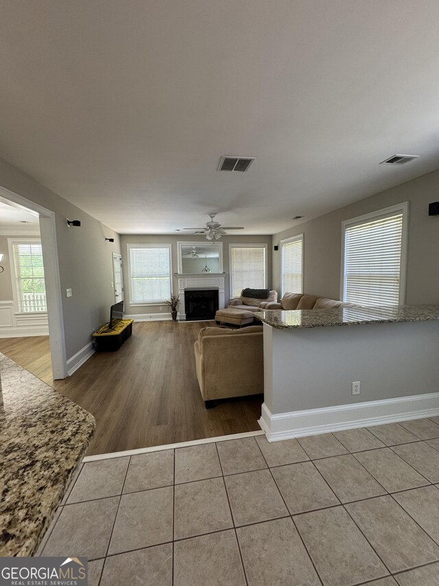 135 Danube Trl, Stockbridge, GA 30281 - living area with a fireplace, light tile patterned floors, visible vents, and baseboards