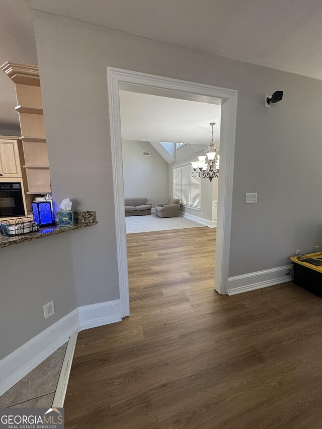 135 Danube Trl, Stockbridge, GA 30281 - hall featuring baseboards, an inviting chandelier, and wood finished floors