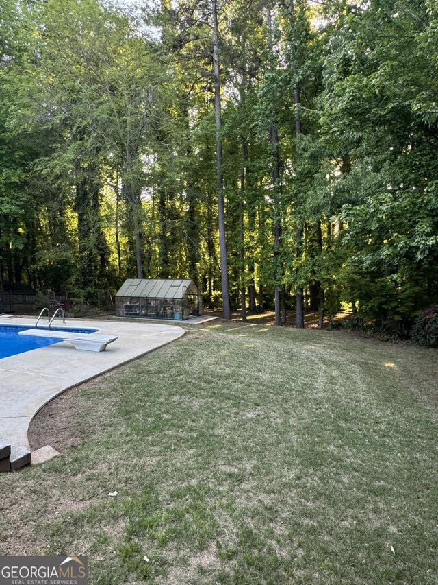 135 Danube Trl, Stockbridge, GA 30281 - view of yard featuring an outdoor pool, a view of trees, and an outdoor structure