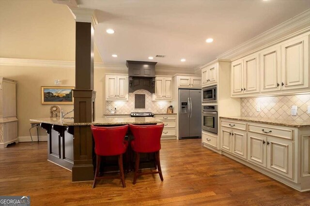 1786 Cambridge Sq, Watkinsville, GA 30677 - kitchen with crown molding, stainless steel appliances, custom range hood, decorative backsplash, and light stone counters