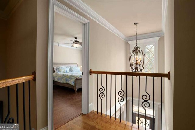 1786 Cambridge Sq, Watkinsville, GA 30677 - hallway with an inviting chandelier, an upstairs landing, ornamental molding, and wood finished floors
