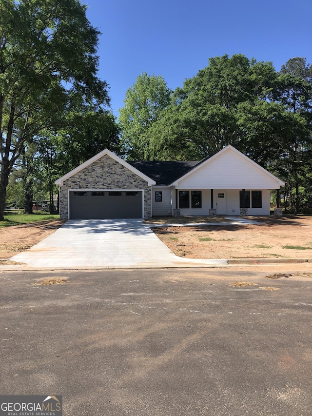 2303 12th Ave, Valley, AL 36854 - view of front facade featuring stone siding, a garage, and concrete driveway