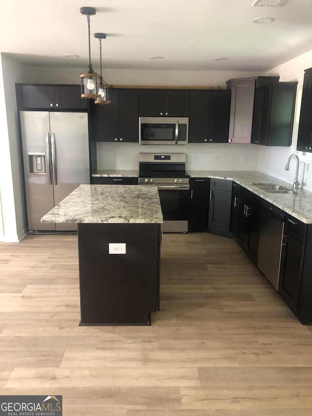 2303 12th Ave, Valley, AL 36854 - kitchen featuring decorative light fixtures, a sink, dark cabinetry, stainless steel appliances, and a kitchen island
