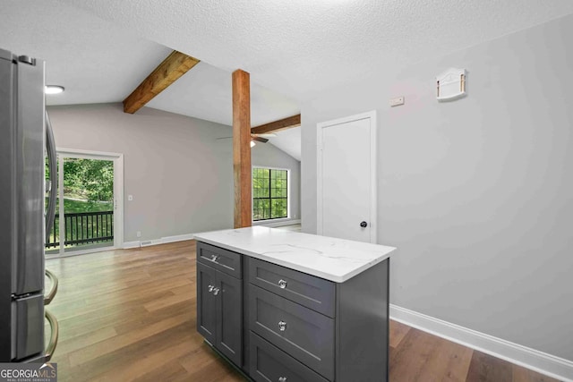 kitchen with freestanding refrigerator, wood finished floors, baseboards, and lofted ceiling with beams
