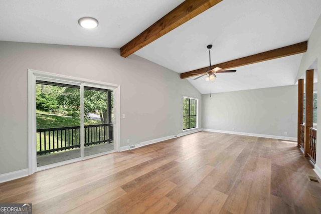 unfurnished living room with wood finished floors, a ceiling fan, baseboards, and lofted ceiling with beams
