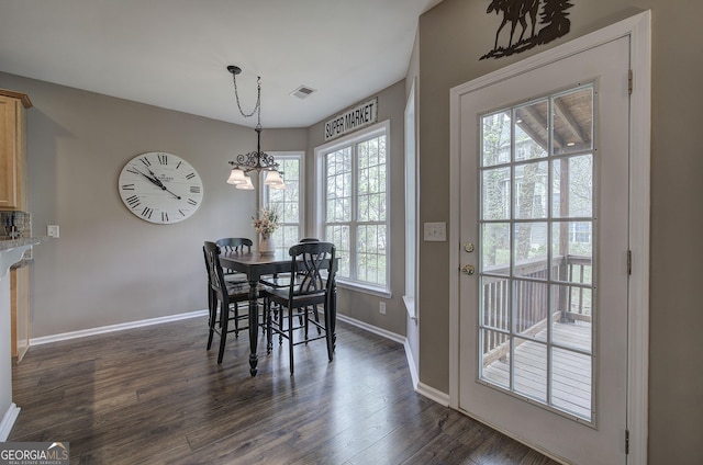 dining space featuring dark wood-type flooring, visible vents, baseboards, and plenty of natural light