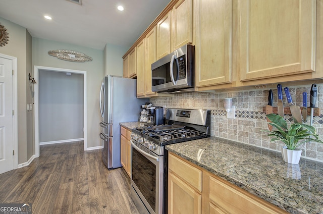 kitchen featuring baseboards, dark wood-type flooring, decorative backsplash, stainless steel appliances, and light brown cabinetry