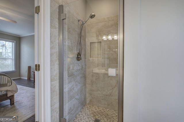 bathroom featuring baseboards, crown molding, and a stall shower