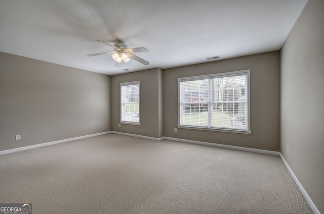 unfurnished room featuring visible vents, baseboards, a ceiling fan, and light carpet