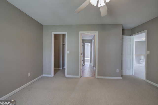 unfurnished bedroom with ceiling fan, light colored carpet, and baseboards