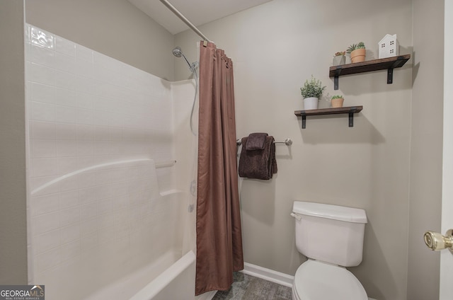 bathroom with toilet, shower / bath combination with curtain, and baseboards