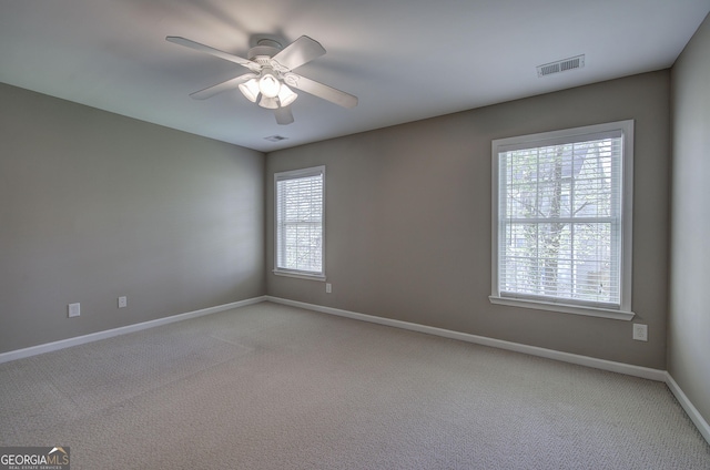unfurnished room with visible vents, baseboards, a ceiling fan, and light carpet