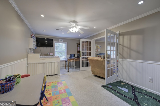 interior space with french doors, ornamental molding, and wainscoting
