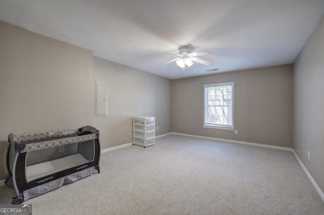 carpeted spare room featuring visible vents, ceiling fan, and baseboards