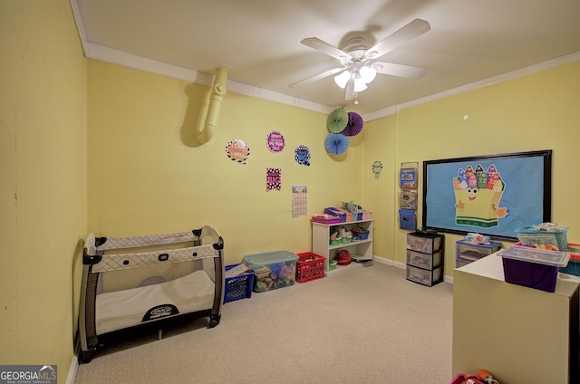 playroom featuring carpet, baseboards, a ceiling fan, and ornamental molding