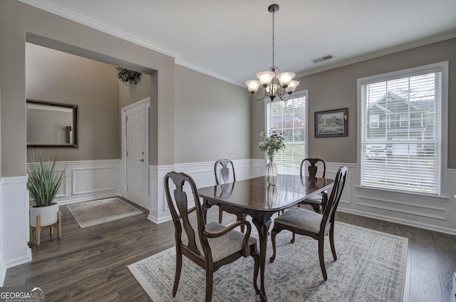 dining space with visible vents, a notable chandelier, ornamental molding, dark wood-style floors, and wainscoting
