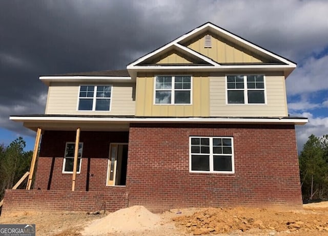 view of front facade featuring brick siding and board and batten siding