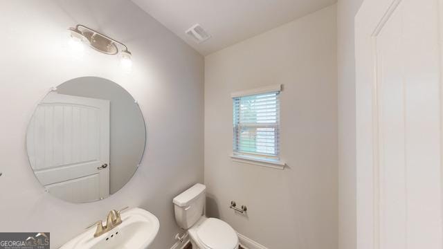 bathroom with visible vents, baseboards, a sink, and toilet