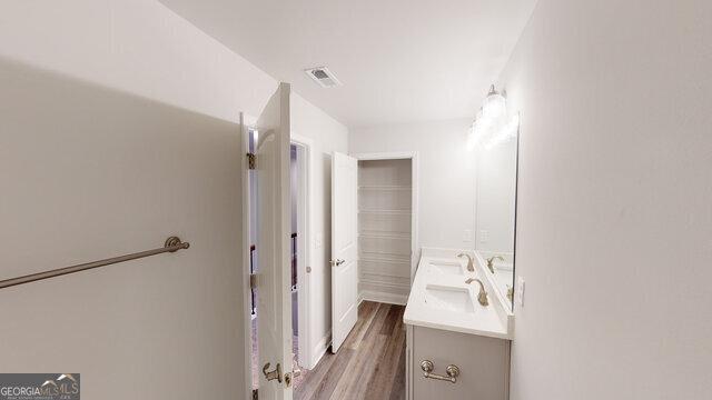 bathroom with wood finished floors, vanity, and visible vents