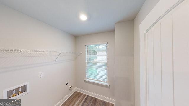 clothes washing area with baseboards, washer hookup, laundry area, dark wood-style floors, and hookup for an electric dryer